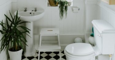 Organized Kids Bathroom with Step Stool and Black and White Floor Tiles