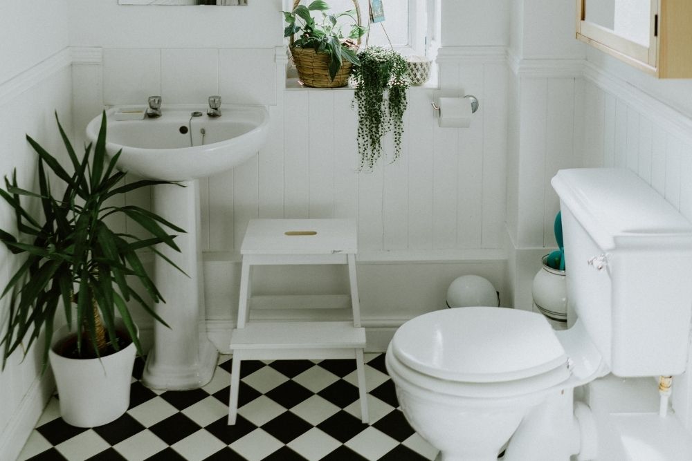 Organized Kids Bathroom with Step Stool and Black and White Floor Tiles