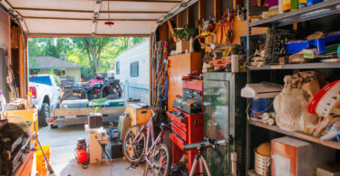 Garage lined with shelves full of things stored at home including, tools, cleaning supplies, holiday decorations and sporting equipment