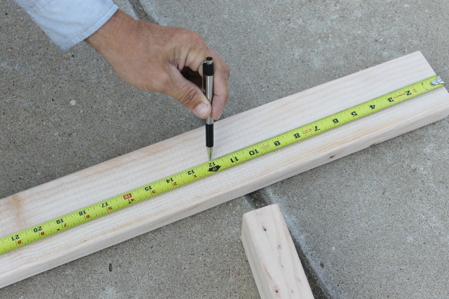diy blanket ladder tutorial - tape measure on 2x4 to measure rung location