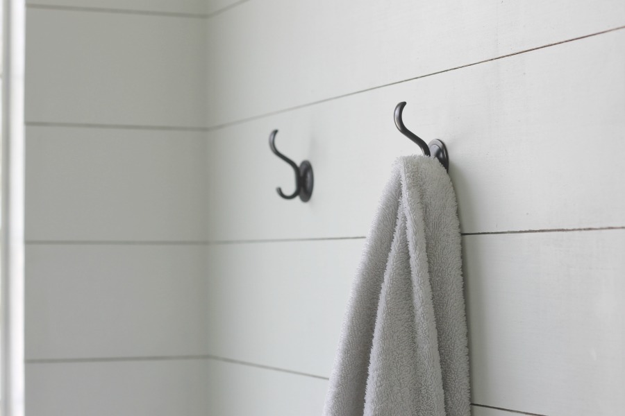 One of our favorite small bathroom storage ideas: instead of towel bars, which can only hold one or two towels, try hooks.