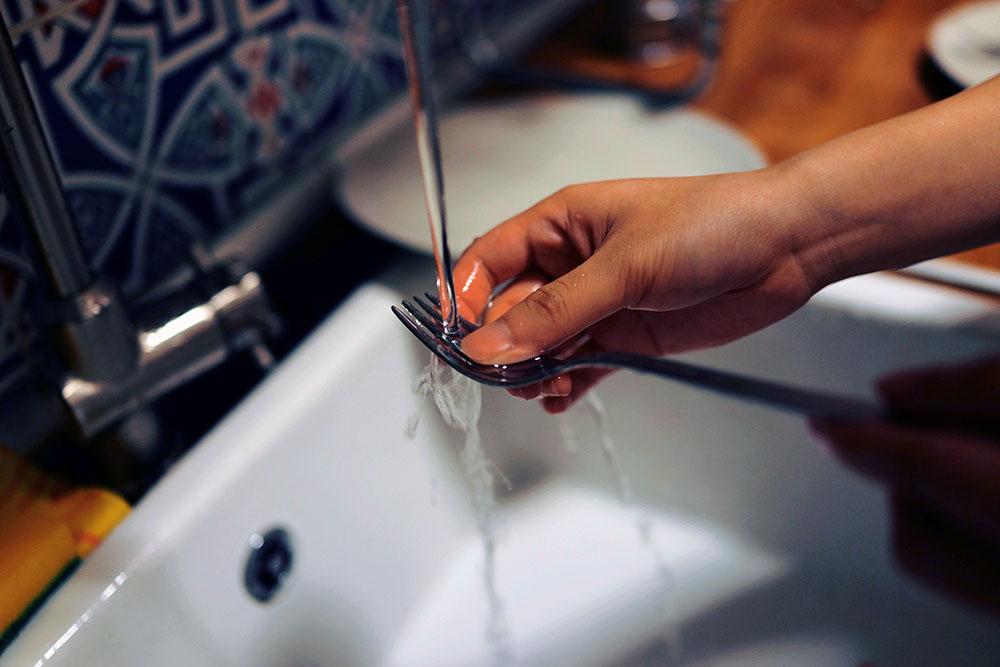 How to keep a house clean: woman doing dishes right away
