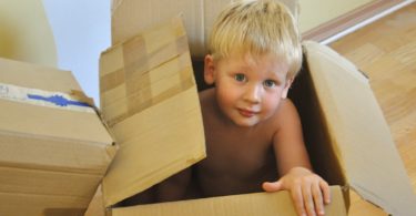 Moving with children tips - blond boy moving box