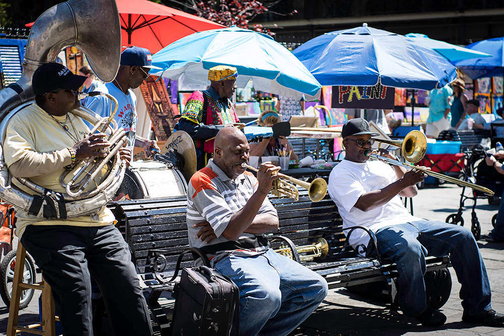 Man playing trumpet, man playing trombone, man playing french horn at Mardi Gras - Moving to New Orleans