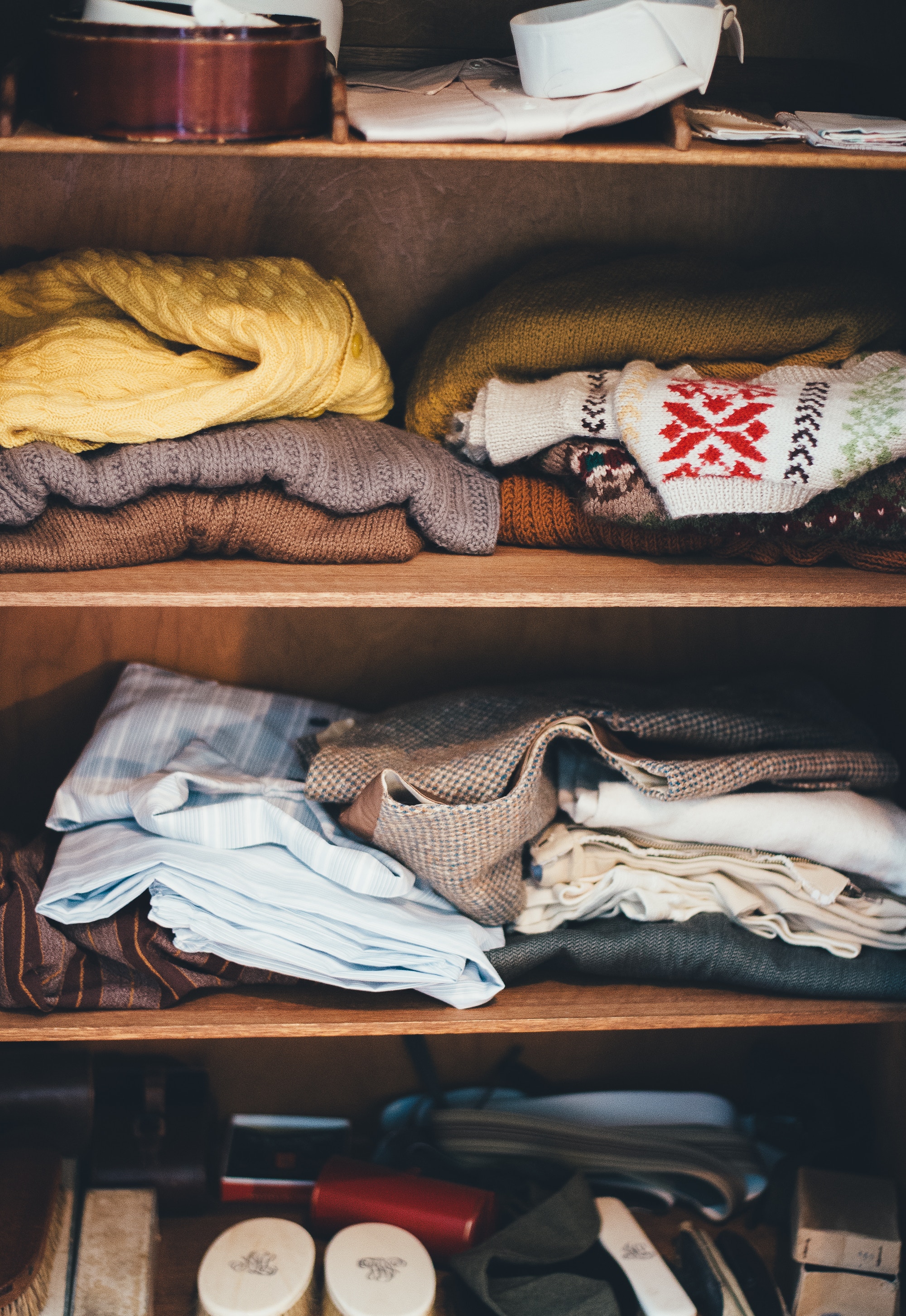 Folded sweaters stored on a shelf