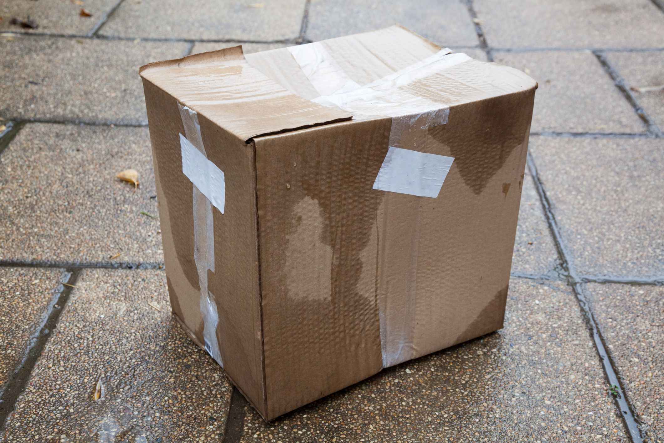 wet cardboard box on the ground - moving in the rain